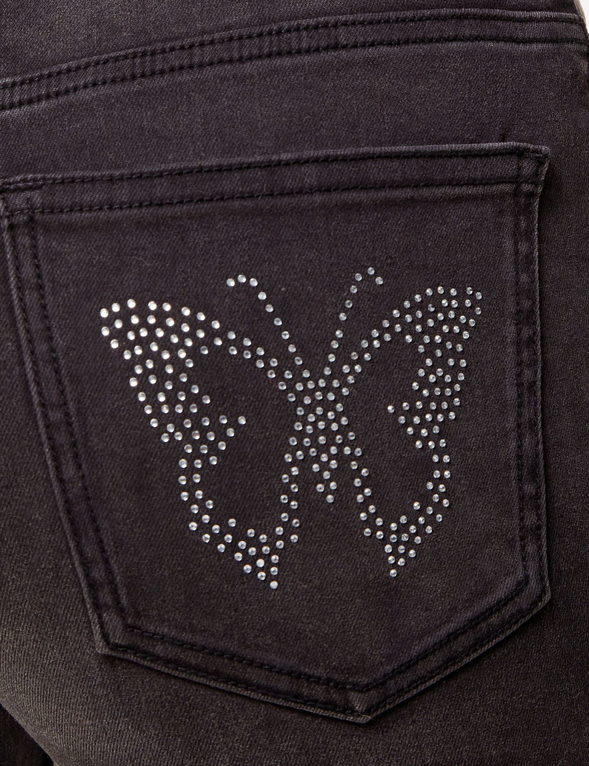 Jean flare noir avec papillons en strass sur les poches du dos